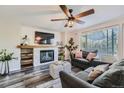 Cozy living room features a fireplace, ceiling fan, and plenty of natural light at 16685 Trail Sky Cir, Parker, CO 80134