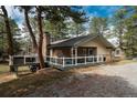 Exterior view of a well-maintained home featuring a deck and surrounded by trees at 5382 S Pine Rd, Evergreen, CO 80439