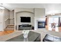 Open living area with fireplace, media center, and stairs leading to second story with hardwood and carpet flooring at 471 N Jackson Gap Way, Aurora, CO 80018