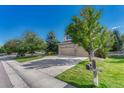 Inviting street view of a well-manicured lawn and a charming home with mature trees at 598 Crossing Cir, Castle Pines, CO 80108