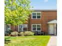 Charming brick townhome featuring a well-manicured lawn and mature shade trees at 2872 Jasmine St, Denver, CO 80207