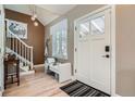 Welcoming entryway with stylish light fixture, wood floors, bench seat, and staircase at 821 S High St, Denver, CO 80209