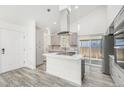 Bright kitchen featuring a center island with cooktop, sleek countertops, and stainless steel refrigerator at 1923 Ensenada Ct, Aurora, CO 80011