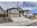 Two-story house with gray siding, stone accents, and a two-car garage at 2905 Morningbird Ln, Castle Rock, CO 80109