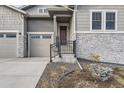 Front entrance with stone accents and a metal railing staircase at 2905 Morningbird Ln, Castle Rock, CO 80109