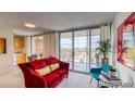 Living room with red couch and sliding glass door to balcony at 4800 E Hale Pkwy # 709N, Denver, CO 80220