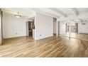 Open-concept living space featuring light wood floors, white walls and ceiling beams at 100 S Clarkson St # 304, Denver, CO 80209