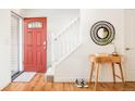 Bright entryway with red door, staircase, and small table at 6021 Yarrow St # B12, Arvada, CO 80004