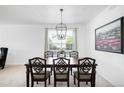Elegant dining room featuring a modern chandelier, large painting, and a window at 5861 Mt Shadows Blvd, Firestone, CO 80504