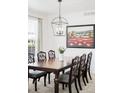 Elegant dining room featuring a dark wood table, decorative chairs, and a modern chandelier at 5861 Mt Shadows Blvd, Firestone, CO 80504