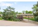 A beautiful, private, ranch-style home behind a wrought iron gate and mature landscaping at 9045 W Ithaca Pl, Denver, CO 80235