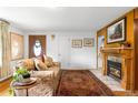 Cozy living room with a fireplace, wood trim, plush furnishings, and a decorative rug at 9045 W Ithaca Pl, Denver, CO 80235