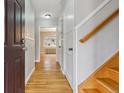 Bright hallway featuring hardwood floors, classic trim, and a staircase leading to the upper level at 275 Pontiac St, Denver, CO 80220