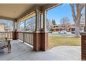 Inviting covered porch with brick pillars and wooden railings, offering a relaxing outdoor space at 275 Pontiac St, Denver, CO 80220