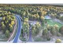 Breathtaking aerial view of a home nestled in a lush green forest setting with winding roads at 18330 Archers Dr, Monument, CO 80132