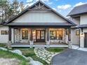 Inviting front porch with stone pillars and wood beam details, offering a warm welcome to this charming home at 18330 Archers Dr, Monument, CO 80132