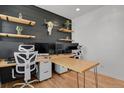 Bright home office featuring a black accent wall and custom-built desk with hairpin legs at 897 E Rim Rd, Franktown, CO 80116