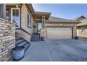 Attractive home featuring a two-car garage, stone accents, and a welcoming entrance at 23960 E Easter Pl, Aurora, CO 80016
