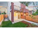 Townhome exterior with a private fenced front yard, small porch, and lawn at 1048 Knox Ct, Denver, CO 80204