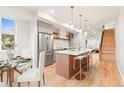 Modern kitchen with stainless appliances, island with bar stools, and hardwood floors at 1048 Knox Ct, Denver, CO 80204