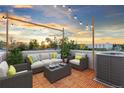 Outdoor patio features lounge seating with string lights and city views at 1048 Knox Ct, Denver, CO 80204