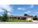 Charming home with solar panels, a well-maintained lawn, an American flag, and an attached garage at 11835 W 37Th Pl, Wheat Ridge, CO 80033