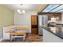 Eat-in kitchen boasts a breakfast nook, stainless steel appliances, and natural wood cabinets at 10890 W Evans Ave # 1G, Lakewood, CO 80227