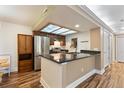 Open kitchen with stainless steel appliances, granite counters, and stylish wood flooring at 10890 W Evans Ave # 1G, Lakewood, CO 80227