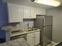 Well-lit kitchen featuring white cabinets, stainless steel appliances, and granite countertops at 8600 E Alameda Ave # 105, Denver, CO 80247