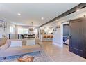 Open-concept living space showcases a modern design with exposed beam, hardwood floors, and seamless flow to the kitchen at 2337 S Franklin St, Denver, CO 80210