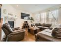 Comfortable living room features a cozy fireplace, hardwood flooring, and plenty of natural light at 13341 Olive St, Thornton, CO 80602