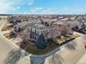 View of the gray home showing the neighborhood, surrounding streets, and the landscaped front yard at 8775 Wild Horse Way, Frederick, CO 80504