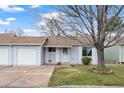 Charming single-story home with a well-manicured lawn and a mature tree in a quiet community at 16120 E Radcliff Pl, Aurora, CO 80015