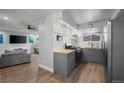 Updated kitchen features sleek gray cabinets, stainless steel appliances, and wooden flooring with an open access to the living room at 16120 E Radcliff Pl, Aurora, CO 80015