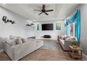 Spacious living room boasts a ceiling fan, comfortable seating, and a large flat-screen TV at 16120 E Radcliff Pl, Aurora, CO 80015