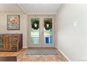 Inviting foyer with brick floors, decorative rug, and charming cabinet at 3807 S Jasmine St, Denver, CO 80237