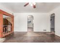 Spacious living room with hardwood floors, white walls, and archway to the kitchen at 3280 Ames St, Wheat Ridge, CO 80212