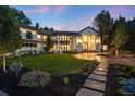 Elegant two-story home with manicured front lawn and stone walkway leading to a grand entrance framed by stylish lighting at 4736 S Fillmore Ct, Cherry Hills Village, CO 80113