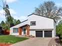 Inviting home exterior featuring a two-car garage, manicured lawn, and natural wood porch supports at 4484 S Granby Ct, Aurora, CO 80015
