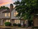 Charming two-story townhome with brick accents, mature landscaping, and a classic chimney at dusk at 3086 W 107Th Pl # F, Westminster, CO 80031