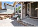 Inviting front porch with porch swing, potted flowers, and decorative lanterns, creating a cozy entryway at 3102 Fox Sedge Pl, Highlands Ranch, CO 80126
