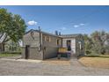 The exterior of the home features a fenced yard, a garage, brick accents, and a well-manicured lawn at 5555 Julian St, Denver, CO 80221