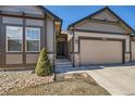 Charming exterior with a two-car garage, stone accents, and a well-maintained lawn at 11926 Barrentine Loop, Parker, CO 80138