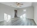 Spacious living room with updated gray floors, a modern ceiling fan, and an open doorway at 1437 N Uinta St, Denver, CO 80220