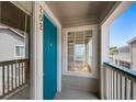 A charming front porch entryway features a vibrant blue door and sunny window at 8437 Thunder Ridge Way # 202, Highlands Ranch, CO 80126