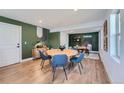 Well-lit dining room with a round wooden table, comfortable blue chairs, and modern decor at 15290 W 69Th Pl, Arvada, CO 80007