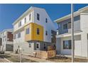 Modern two-story home with stylish white, yellow, and gray siding and a well-maintained lawn at 15290 W 69Th Pl, Arvada, CO 80007