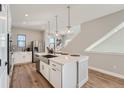 Open kitchen layout with an island, stainless steel appliances, and a view of the staircase at 15290 W 69Th Pl, Arvada, CO 80007