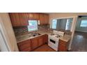 Bright kitchen featuring wood cabinets, granite countertops, tile backsplash, and a gas range stove at 2880 W 91St Pl, Denver, CO 80260