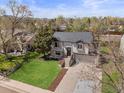 A beautiful elevated view showcasing this home with a well-manicured lawn, mature trees and attractive landscaping at 10895 W Bowles Pl, Littleton, CO 80127
